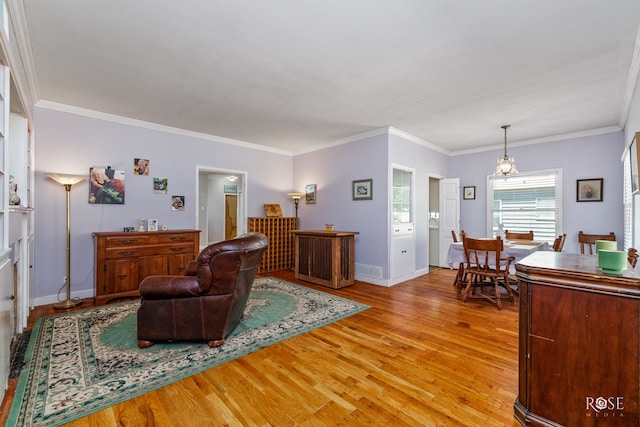 living room with crown molding and light hardwood / wood-style flooring