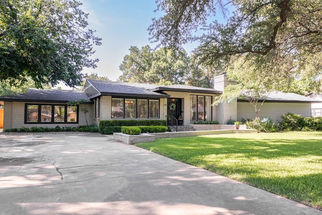 2611 Live Oak St, San Angelo, TX 76901 - view of front of property with a front yard, a chimney, and brick siding