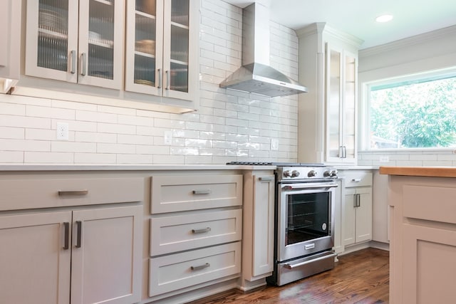 2611 Live Oak St, San Angelo, TX 76901 - kitchen with high end stainless steel range oven, wall chimney range hood, ornamental molding, glass insert cabinets, and decorative backsplash