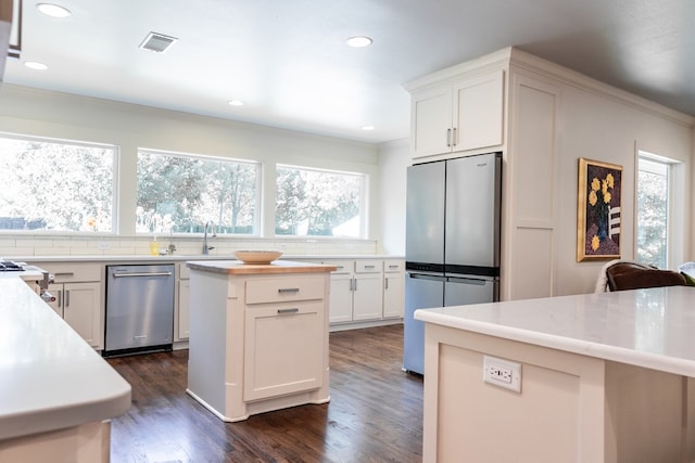 2611 Live Oak St, San Angelo, TX 76901 - kitchen with stainless steel appliances, tasteful backsplash, dark wood finished floors, white cabinetry, and recessed lighting