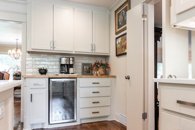 2611 Live Oak St, San Angelo, TX 76901 - indoor bar featuring beverage cooler, backsplash, dark wood-type flooring, and a chandelier