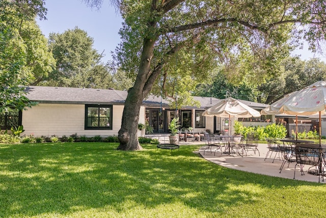 2611 Live Oak St, San Angelo, TX 76901 - rear view of property with a lawn and a patio