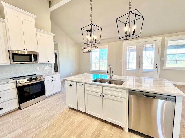 kitchen featuring sink, hanging light fixtures, white cabinets, and appliances with stainless steel finishes