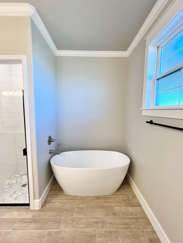 bathroom with ornamental molding and shower with separate bathtub