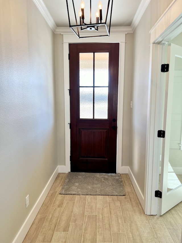 foyer with ornamental molding and a chandelier