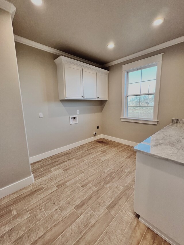 washroom featuring electric dryer hookup, hookup for a washing machine, ornamental molding, and cabinets