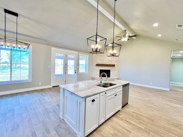 kitchen featuring dishwasher, sink, pendant lighting, and white cabinets