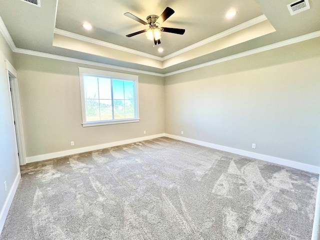 unfurnished room with crown molding, a tray ceiling, carpet floors, and ceiling fan