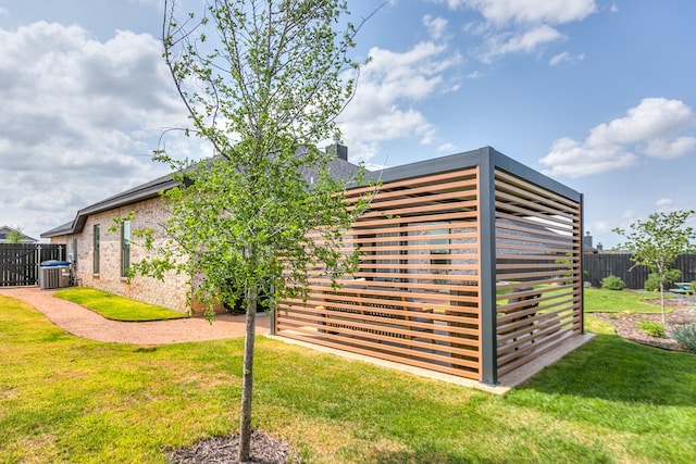 view of outdoor structure featuring central air condition unit and fence