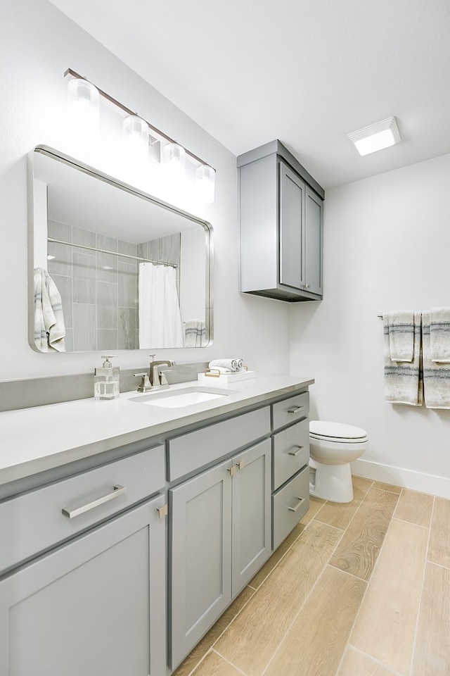 bathroom featuring vanity, wood tiled floor, curtained shower, and toilet