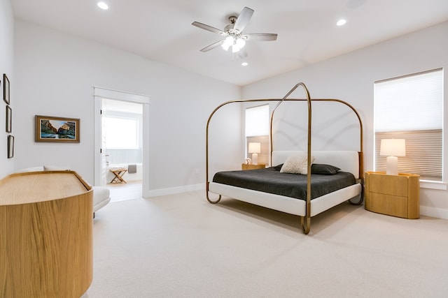 bedroom featuring light colored carpet, recessed lighting, baseboards, and ensuite bath