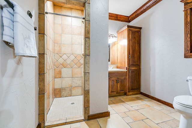 bathroom with ornamental molding, tiled shower, vanity, and toilet