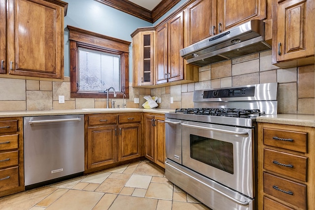 kitchen with crown molding, appliances with stainless steel finishes, sink, and decorative backsplash