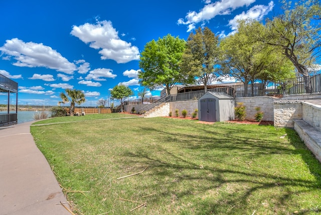 view of yard featuring a water view and a storage shed