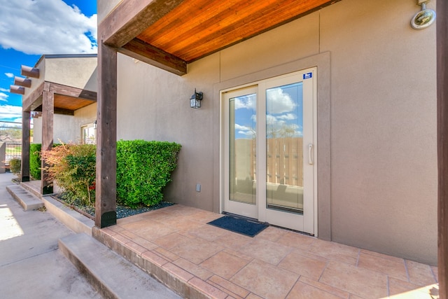 view of exterior entry with a patio