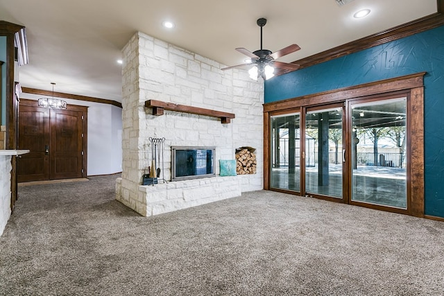 unfurnished living room featuring crown molding, a stone fireplace, ceiling fan, and carpet