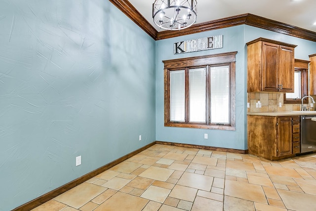 kitchen with pendant lighting, sink, decorative backsplash, stainless steel dishwasher, and crown molding