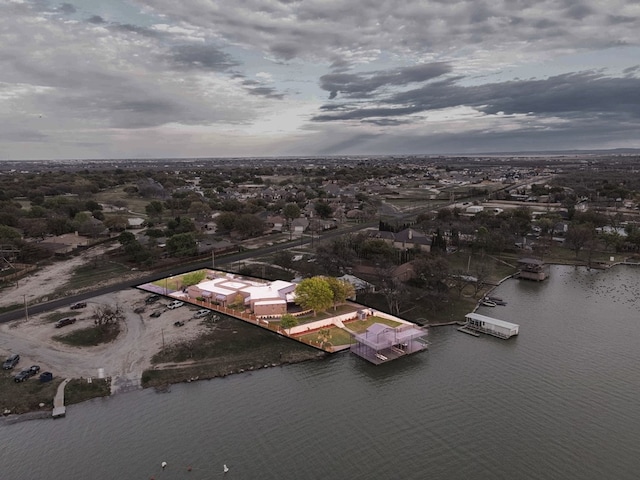 aerial view at dusk featuring a water view