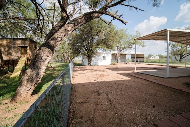 view of yard with a carport and fence