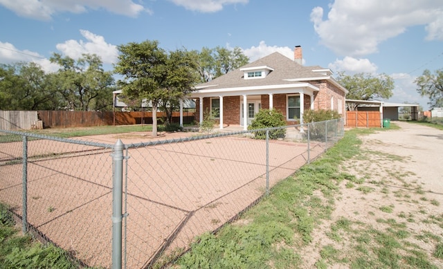 view of front of house featuring brick siding, fence, and a chimney