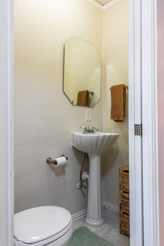 bathroom featuring crown molding, tile patterned floors, and toilet