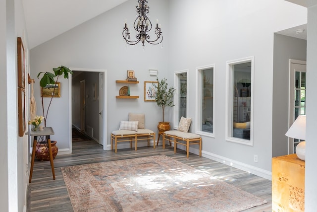 sitting room with dark hardwood / wood-style flooring, a chandelier, and high vaulted ceiling