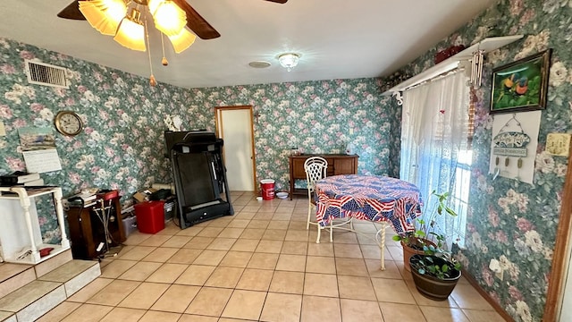 dining space with light tile patterned floors, a ceiling fan, visible vents, and wallpapered walls