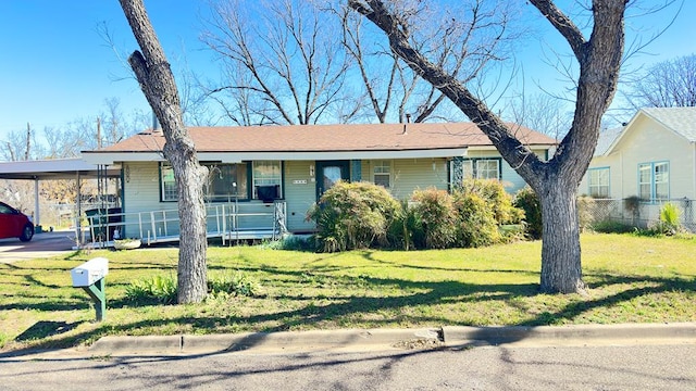 ranch-style home with a porch, a front lawn, and a carport