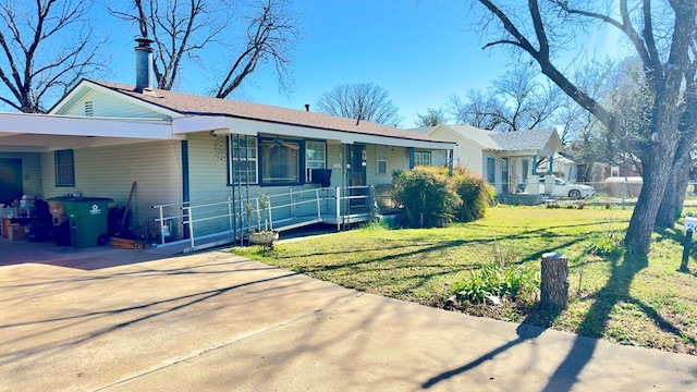 ranch-style home featuring covered porch, concrete driveway, a front lawn, and an attached carport