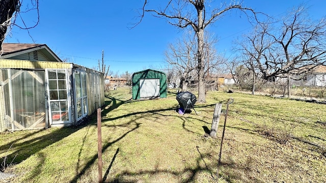 view of yard with an outbuilding, fence, and a storage shed