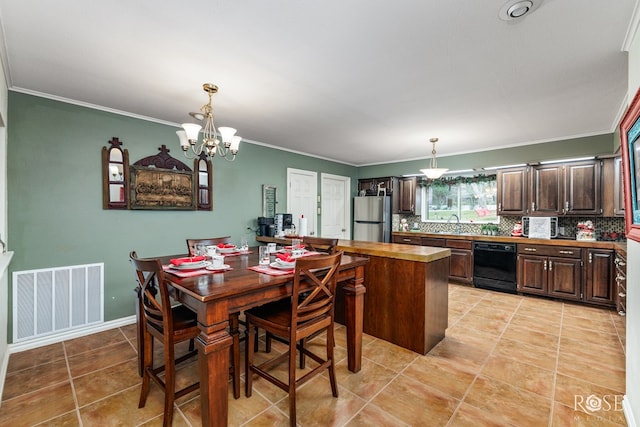 dining room featuring a notable chandelier, crown molding, and sink