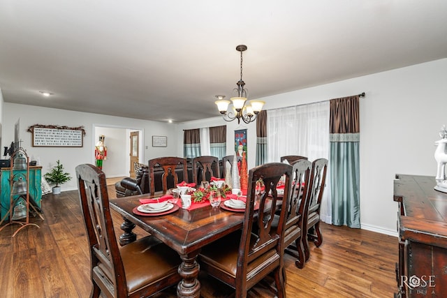 dining area with a notable chandelier and dark hardwood / wood-style floors