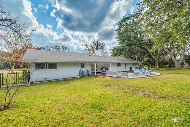 rear view of property with a lawn and a patio area