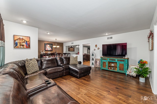 living room featuring dark hardwood / wood-style flooring and an inviting chandelier