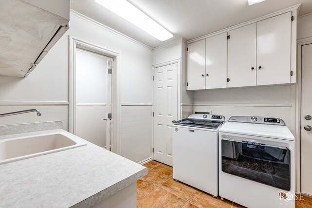 washroom featuring cabinets, sink, tile walls, and washing machine and clothes dryer