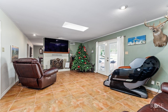 living room featuring french doors, crown molding, a fireplace, and a skylight