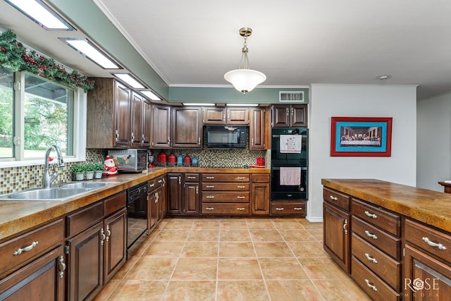 kitchen featuring sink, hanging light fixtures, tasteful backsplash, black appliances, and light tile patterned flooring