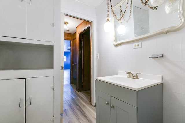 512 Ave J, Ozona, TX 76943 - bathroom featuring vanity, tile walls, and wood finished floors