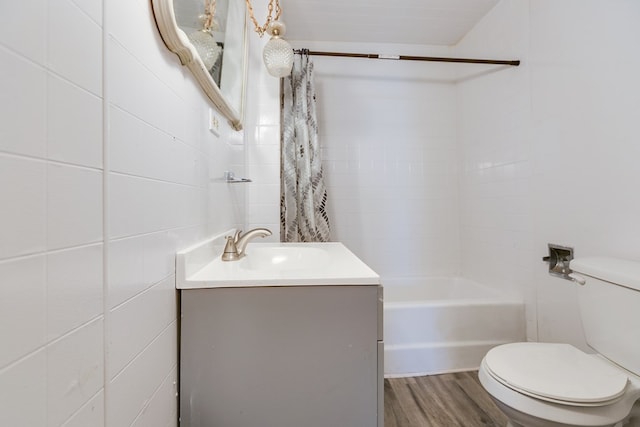 512 Ave J, Ozona, TX 76943 - bathroom featuring shower / tub combo with curtain, toilet, wood finished floors, tile walls, and vanity
