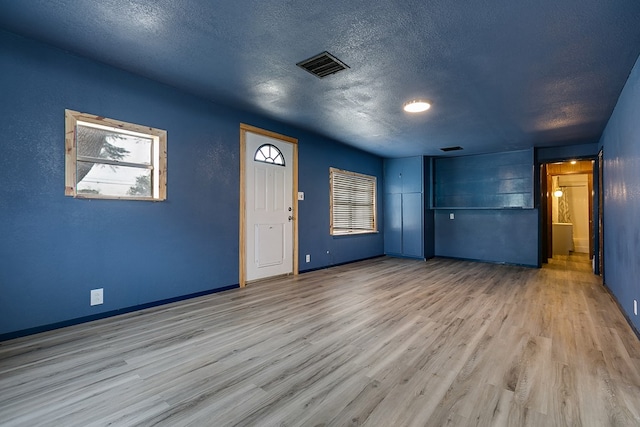 512 Ave J, Ozona, TX 76943 - unfurnished room featuring visible vents, a textured ceiling, baseboards, and wood finished floors