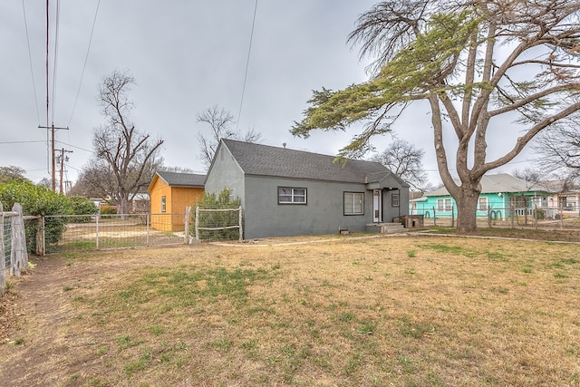 512 Ave J, Ozona, TX 76943 - rear view of house featuring stucco siding, a lawn, and fence