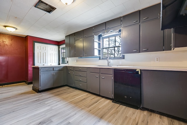 512 Ave J, Ozona, TX 76943 - kitchen featuring light wood finished floors, visible vents, light countertops, black dishwasher, and a sink