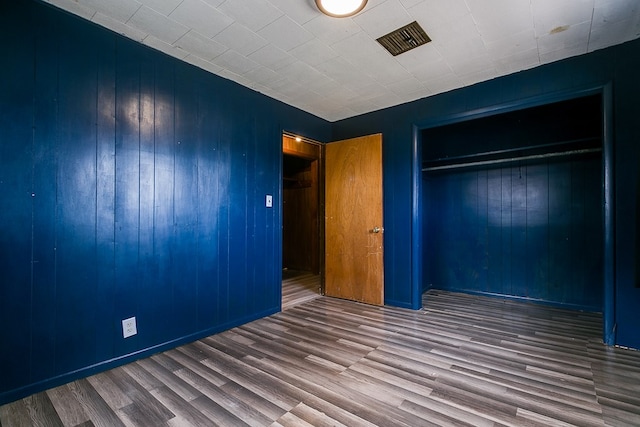 512 Ave J, Ozona, TX 76943 - unfurnished bedroom featuring a closet, visible vents, and wood finished floors