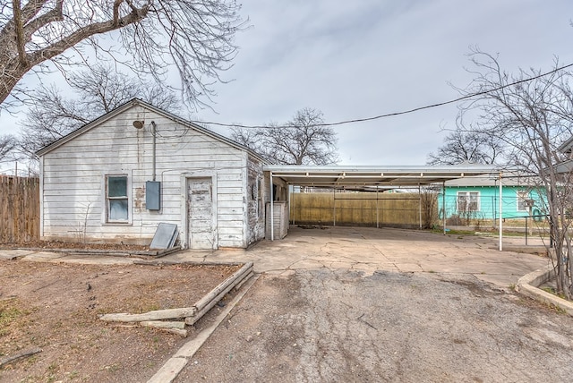 512 Ave J, Ozona, TX 76943 - view of outbuilding featuring an attached carport, fence, and driveway