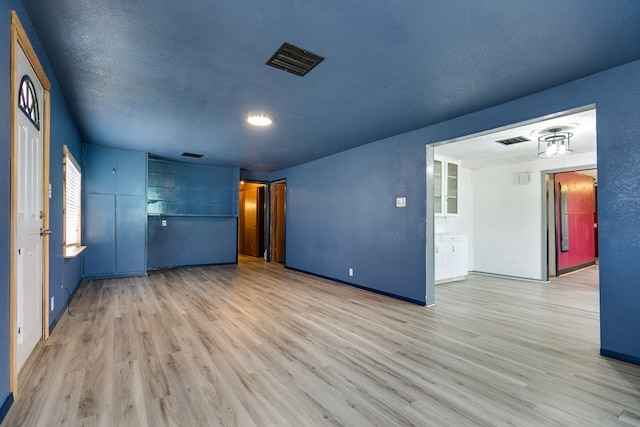 512 Ave J, Ozona, TX 76943 - unfurnished room with visible vents, a textured ceiling, and wood finished floors