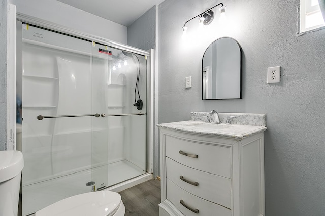 512 Ave J, Ozona, TX 76943 - full bath with wood finished floors, toilet, a textured wall, and a shower stall