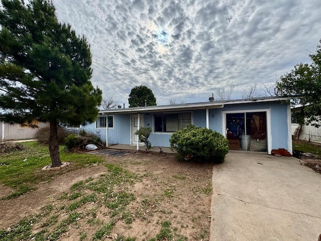 view of front of house featuring a garage, fence, and driveway