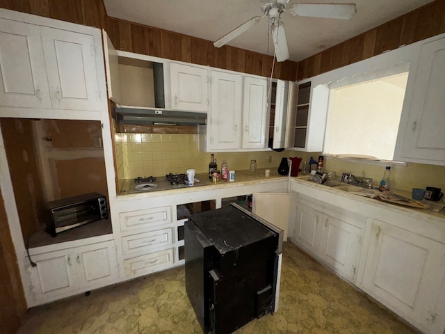 kitchen featuring white cabinets, decorative backsplash, white cooktop, light countertops, and light floors