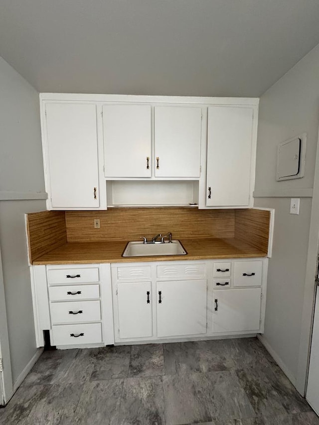 kitchen featuring sink and white cabinets