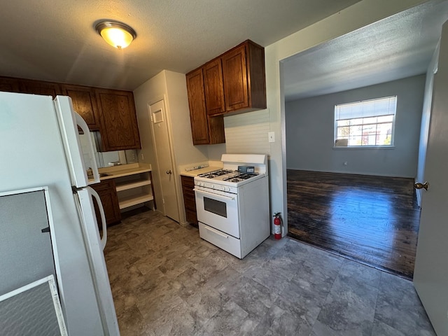 kitchen featuring white appliances and a textured ceiling